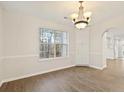 Well-lit dining room area with a chandelier and large window with vinyl flooring at 2317 Rocksram Ct, Buford, GA 30519