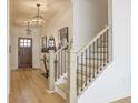 Elegant home entryway with wood floors, decorative lighting, and a staircase with metal spindles at 1715 Fulmont Cir, Mableton, GA 30126