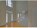 Bright two-story foyer with hardwood floors, staircase, white door, and transom window above at 1871 Birch Briar Bnd, Lawrenceville, GA 30043