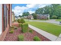 Neighborhood street showcasing landscaped front yards, mature trees and sidewalks, with view from property at 1871 Birch Briar Bnd, Lawrenceville, GA 30043