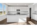 Modern kitchen with white cabinets, stainless steel appliances, and large island with sink at 6935 Melody Ridge Rd, Buford, GA 30518