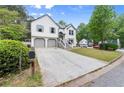 View of the exterior of a two-story home with an extra long driveway surrounded by mature trees and greenery at 4258 Anderson Ridge Way, Austell, GA 30106