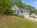 Charming gray split level home with red shutters and well-maintained landscaping at 5525 Tallantworth Trl, Cumming, GA 30040