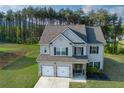 Well-maintained two-story home with attached two-car garage and a lush green lawn at 61 N Village Cir, Rydal, GA 30171