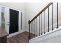 Welcoming foyer with sleek floors, staircase, and bright natural light streaming through the front door at 61 N Village Cir, Rydal, GA 30171