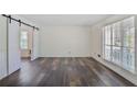 Spacious living room with hardwood floors, sliding barn doors, and ample natural light at 680 Ruxbury Ct, Suwanee, GA 30024