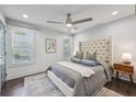 Cozy main bedroom with a large upholstered headboard, soft lighting, and an elegant rug over the hardwood floors at 198 Clay Se St # G, Atlanta, GA 30317