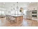 Open concept kitchen features stainless steel appliances, large island with seating, and hardwood floors at 5315 Hendrix Rd, Cumming, GA 30040