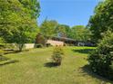 View of the side of the house showing the yard, fence, and driveway on a sunny day at 4589 Mesaview Way, Stone Mountain, GA 30083