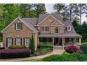 Charming brick home with a welcoming front porch, well-manicured landscaping, and classic architectural details at 176 Nightwind Trce, Acworth, GA 30101