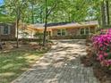Traditional brick home featuring a brick paver driveway and a neatly maintained front yard, surrounded by mature trees at 2735 Shetland Dr, Decatur, GA 30033