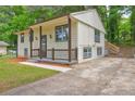 Inviting home with a quaint front porch, concrete driveway, and lush greenery at 6454 Boca Grande Blvd, Forest Park, GA 30297