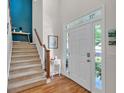 Inviting foyer with hardwood floors, staircase, and natural light from side windows at 905 Fox Croft Pl, Canton, GA 30114