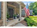 Charming covered front porch with stone accents, rocking chairs, and American flag at 905 Fox Croft Pl, Canton, GA 30114