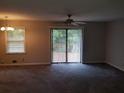 Bright living room with modern ceiling fan, plush carpet, and sliding glass doors at 1170 Blair Bridge Rd, Austell, GA 30168