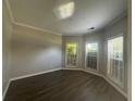 Bedroom with dark wood-look flooring and multiple windows providing ample natural light at 3835 Portico Run Dr, Buford, GA 30519