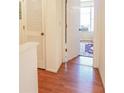 Bright hallway featuring wood floors, an enclosed closet, and natural light coming through the window at 5607 Stonington Trace Pkwy, Stone Mountain, GA 30087