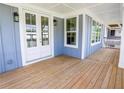 The covered porch features beautiful wood floors, beadboard ceiling, and double glass doors at 1432 Fairmont Ave, Atlanta, GA 30318