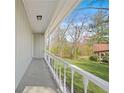 Covered porch with white railing and views of the green lawn and surrounding trees at 200 Harvell Dr, Bowdon, GA 30108