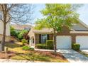Charming brick home with a well-manicured lawn and attached one car garage at 407 Red Coat Ln, Woodstock, GA 30188