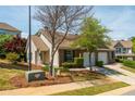 Inviting home with well-maintained landscaping, garage, and sidewalk to front door at 407 Red Coat Ln, Woodstock, GA 30188