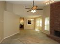 Spacious living room with a brick fireplace, large windows, and ceiling fan at 490 Culberson Sw St, Atlanta, GA 30310