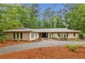 Inviting one-story house with a gravel driveway and mature trees at 11540 Northgate Way, Roswell, GA 30075