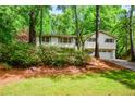 Lovely split-level house featuring an attached two-car garage, surrounded by mature trees and landscaping at 2840 Wendy Ln, Marietta, GA 30062