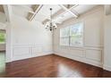 Elegant dining room with coffered ceiling, wainscoting, and hardwood floors at 5705 Aspen Dr, Cumming, GA 30040