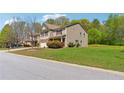 Well-maintained home showcasing a manicured lawn and mature trees in a suburban setting at 5705 Aspen Dr, Cumming, GA 30040