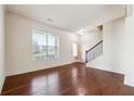 Inviting living room featuring hardwood floors, a large window, and staircase access at 5705 Aspen Dr, Cumming, GA 30040