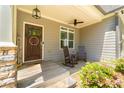 Inviting covered front porch with rocking chairs and a wooden door at 2025 Goldmine Dr, Cumming, GA 30040