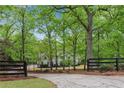 Charming property with a long driveway, lush trees, and a gated entrance at 1400 Squire Ln, Cumming, GA 30041