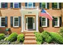Charming front entrance with brick steps, black door, an American flag, and well-maintained landscaping at 2700 Sandstone Dr, Lawrenceville, GA 30043