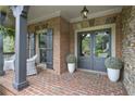 Inviting front porch with brickwork, seating, and decorative plants creating a warm welcome at 101 Fernwood Dr, Woodstock, GA 30188