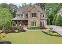 Charming home with lush lawn, colorful flowerbeds, and a welcoming front porch at 101 Fernwood Dr, Woodstock, GA 30188