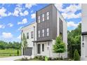 Modern home showcasing a two-story exterior with gray accents, painted brick, landscaping and a manicured lawn at 1420 Coretta Bend, Atlanta, GA 30318