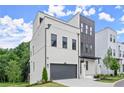 Modern two-story home featuring gray accents, painted brick, a two-car garage, a driveway and manicured front lawn at 1420 Coretta Bend, Atlanta, GA 30318