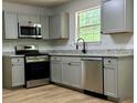 Updated kitchen with stainless steel appliances, granite countertops, and light gray cabinets at 3432 Sumter Pl, Decatur, GA 30034
