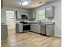 Modern kitchen features gray cabinets, stainless appliances, and wood-look flooring at 3432 Sumter Pl, Decatur, GA 30034