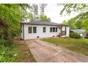 Home with a driveway and yard surrounded by mature trees at 4215 Sherwood Ave, Decatur, GA 30035