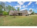 A one story house with a sloping front yard, well maintained lawn, and a sidewalk leading to the front door at 74 Stonegate Ct, Dallas, GA 30157