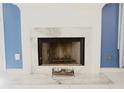 Close-up of a fireplace with marble surround and hearth with decorative elements at 2568 Morning Glory Pl, Lawrenceville, GA 30044