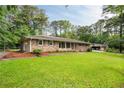 Beautiful brick home with a lush green lawn, landscaping, and a detached garage at 2729 Lanier Dr, Snellville, GA 30078
