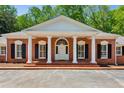 Close up of brick home's entry featuring white columns, black shutters and a beautiful arched door at 3672 Haddon Hall Rd, Atlanta, GA 30327