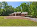 Beautiful brick house surrounded by trees, with a circular driveway and a well-manicured lawn at 3672 Haddon Hall Rd, Atlanta, GA 30327