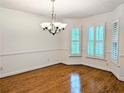Bright dining room featuring hardwood floors, detailed trim, a modern chandelier, and shuttered windows at 1409 Oakridge Cir, Decatur, GA 30033