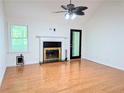Bright living room with hardwood floors, fireplace, ceiling fan, and a large window with natural light at 1409 Oakridge Cir, Decatur, GA 30033