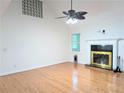 Bright living room features a fireplace, ceiling fan, hardwood floors and large windows at 1409 Oakridge Cir, Decatur, GA 30033