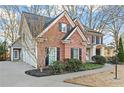 Side view of a brick home featuring a three-car garage and well-maintained landscaping at 607 Crimsonwood Ct, Powder Springs, GA 30127
